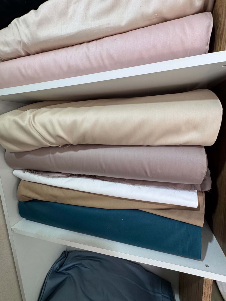 Plain cotton sheets in pink, sand, white and teal on the shop shelves