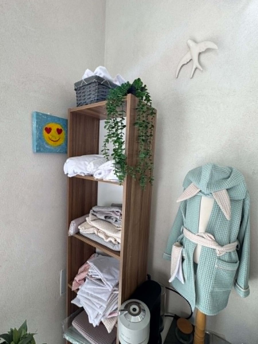 Coin linge de bain de la boutique : serviettes empilées et peignoir vert d'eau